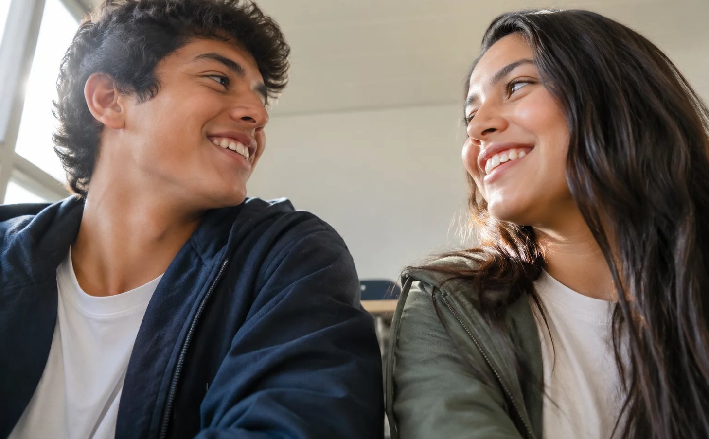 Duas pessoas frente a frente na mesa: uma sustenta a fala, a outra anota o que ouviu